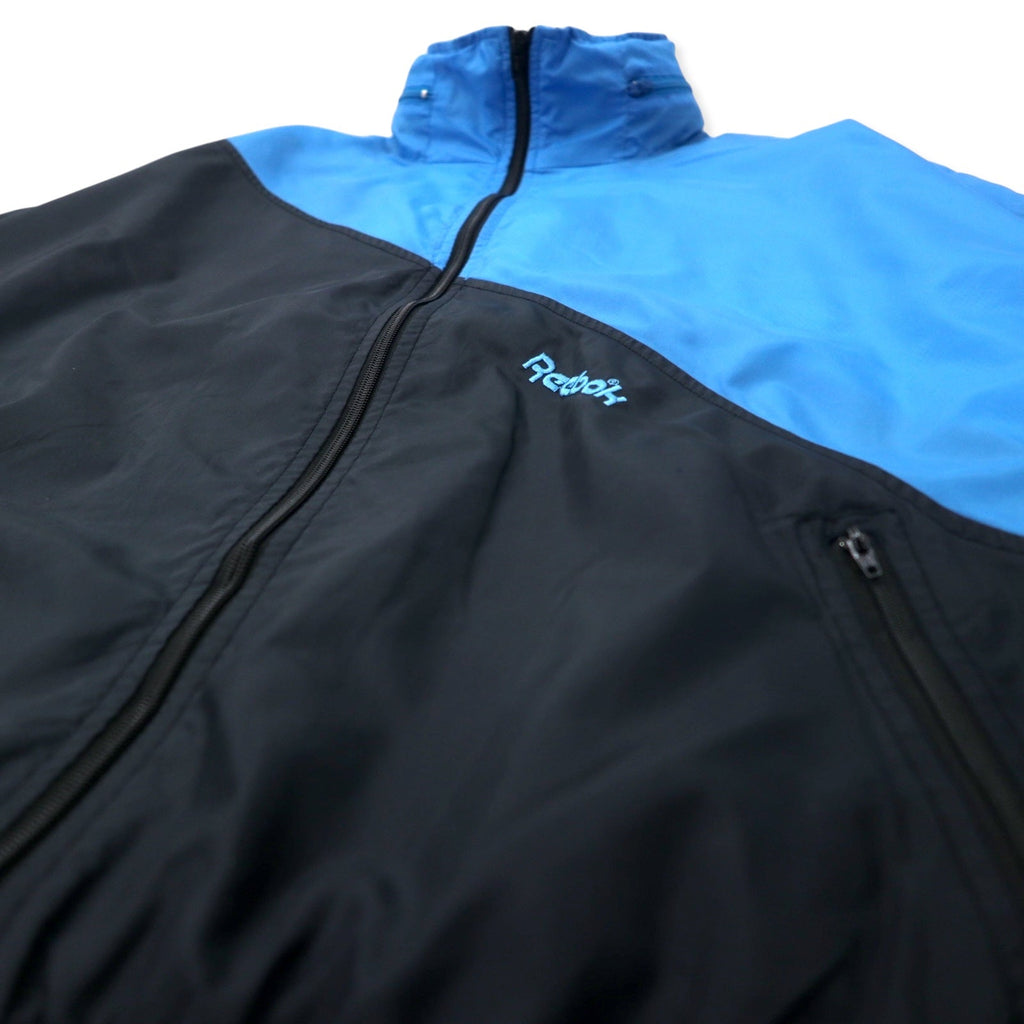 Reebok SPORT Giacca in nylon anni '90, taglia M, blu e nera, cappuccio ripiegabile, logo ricamato sul retro