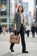 COACHトートバッグを持って颯爽と歩く若い女性